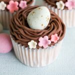 Aqui está uma receita fácil de cupcake de Páscoa com ninho de buttercream de chocolate, recheados com mini ovos.