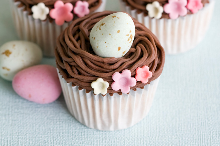 Aqui está uma receita fácil de cupcake de Páscoa com ninho de buttercream de chocolate, recheados com mini ovos.